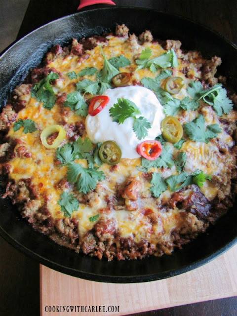 This fun dinner has the flavor of tamales in a quick and fun casserole form. Tamale pie (or casserole if you prefer) is a perfectly flavorful weeknight dinner that is sure to be a hit! close up of tamale casserole topped with ground turkey, melted cheese and all sorts of goodies