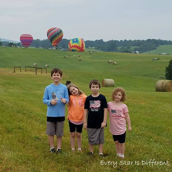 Four kiddos watching the hot air balloon festival.