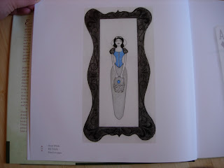Snow White with eyes closed standing or lying down. A drawn frame surrounds her.