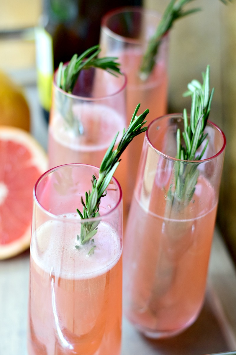 Rosemary Pink Grapefruit Mimosas on a wooden serving tray