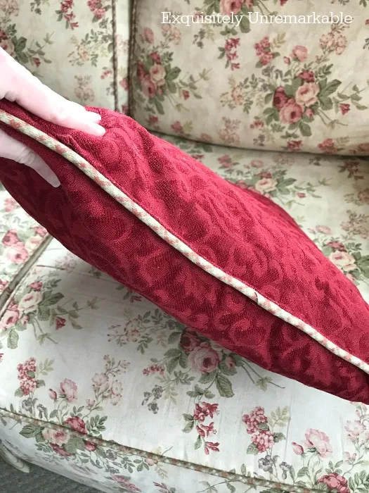 Flat red pillow before stuffing fix on a floral couch