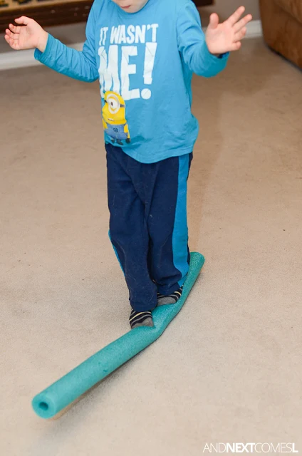 For a quick vestibular gross motor activity for kids, set up this simple DIY balance beam using a pool noodle from And Next Comes L