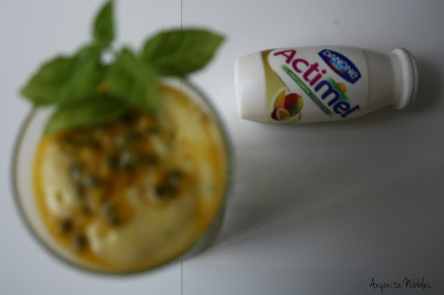 Actimel's mango and passionfruit yogurt with a blurred mango and passion fruit smoothie with fresh basil