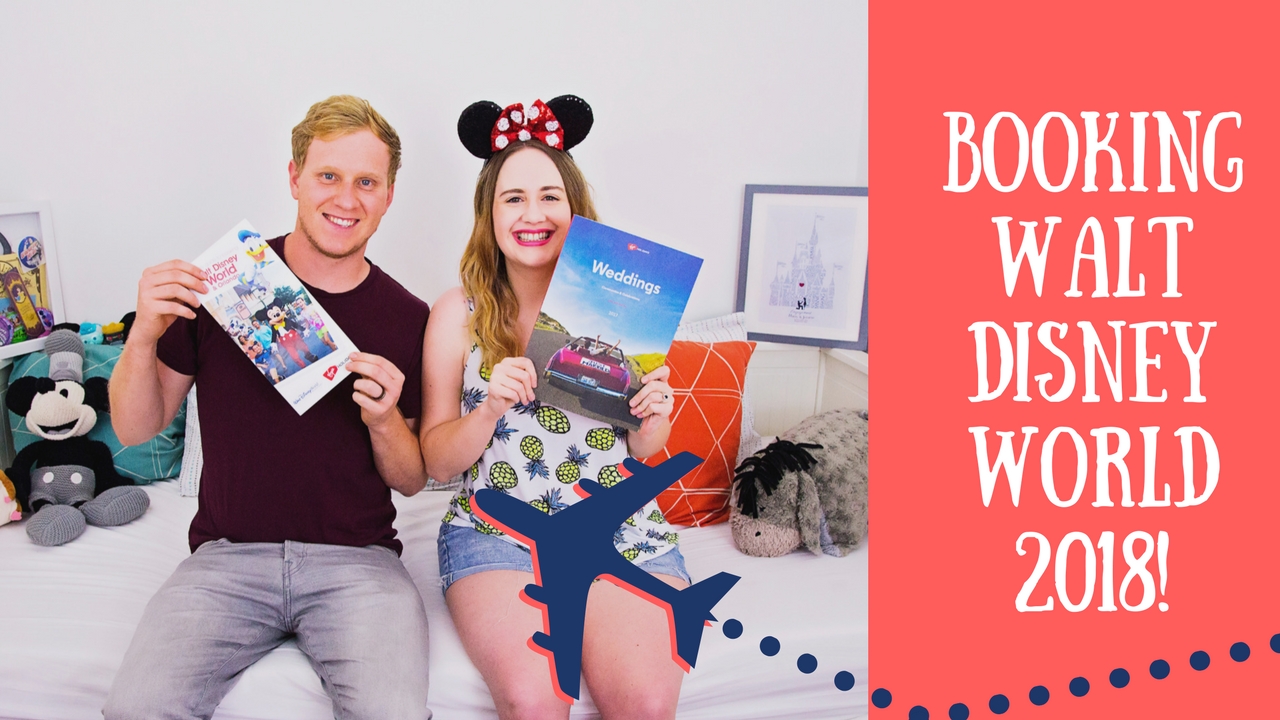 Couple holding up Disney travel brochures.