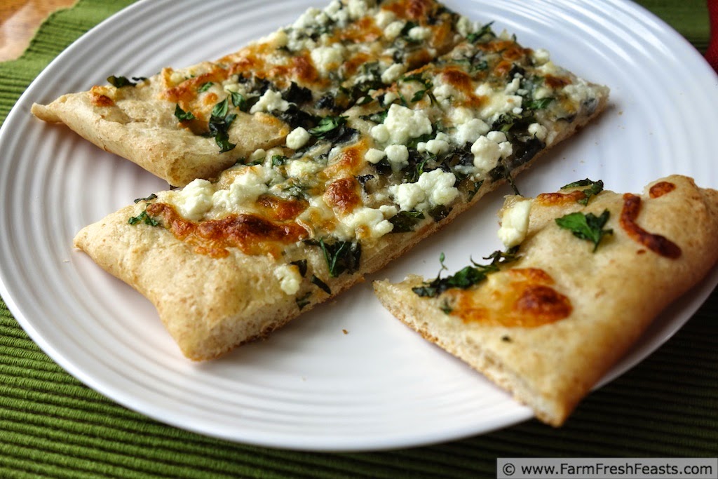 A mix of fresh herbs and a blend of tangy cheeses on roasted garlic oil for a light summer pizza.