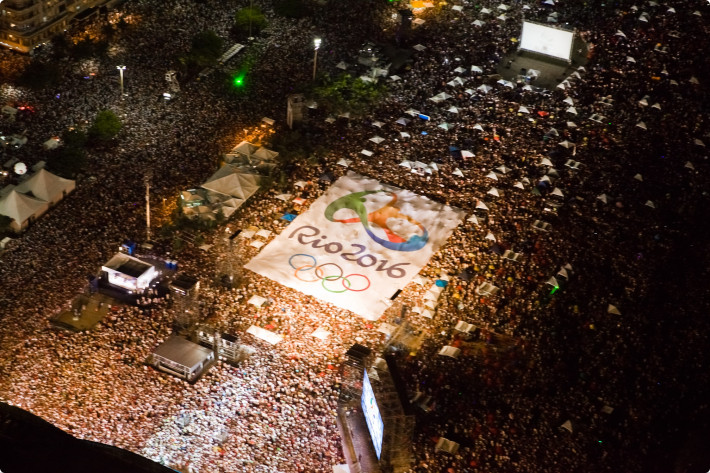 Bandeirão com a marca dos Jogos Olímpicos Rio 2016 foi aberto sobre a multidão na praia de Copacabana, no Rio. Foto: Thor Unamar