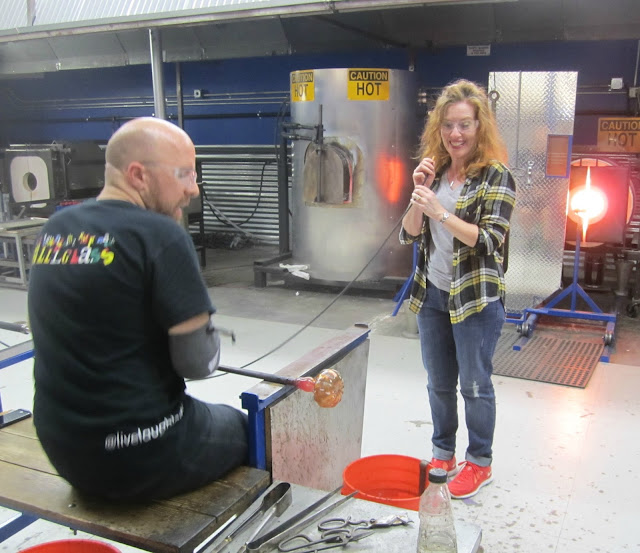 Fizzy Party turning glass into a pumpkin at glass blowing class