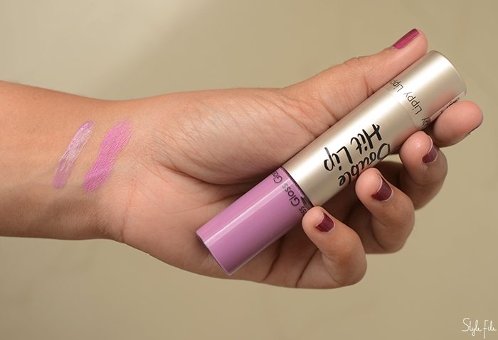 An image of purple lipstick by Look Beauty Berry Blast in a women's hand with purple nails with a lipstick swatch and review 
