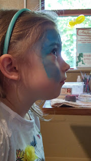 patiently waiting for her face painting 
