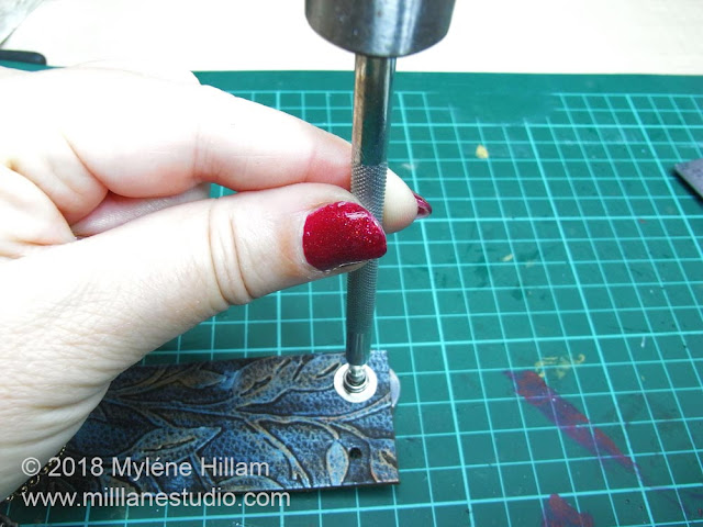 Using a rivet setting tool to set the snaps in the leather