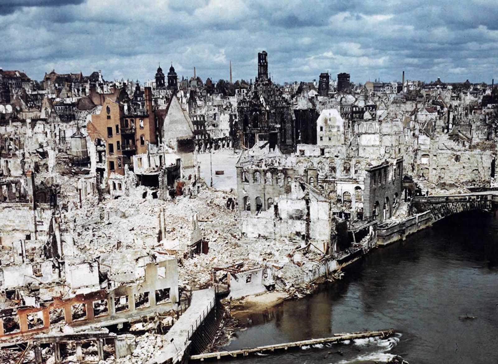 A color photograph of the bombed-out historic city of Nuremberg, Germany in June of 1945, after the end of World War II. Nuremberg had been the host of huge Nazi Party conventions from 1927 to 1938. The last scheduled rally in 1939 was canceled at the last minute due to a scheduling conflict: the German invasion of Poland one day prior to the rally date. The city was also the birthplace of the Nuremberg Laws, a set of draconian antisemitic laws adopted by Nazi Germany. Allied bombings from 1943 until 1945 destroyed more than 90% of the city center, and killed more than 6,000 residents. Nuremberg would soon become famous one last time as the host of the Nuremberg Trials -- a series of military tribunals set up to prosecute the surviving leaders of Nazi Germany. The war crimes these men were charged with included 