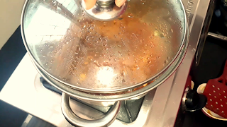 image of opening cover of pot and checking the masala image of opening cover of pot and checking the masala