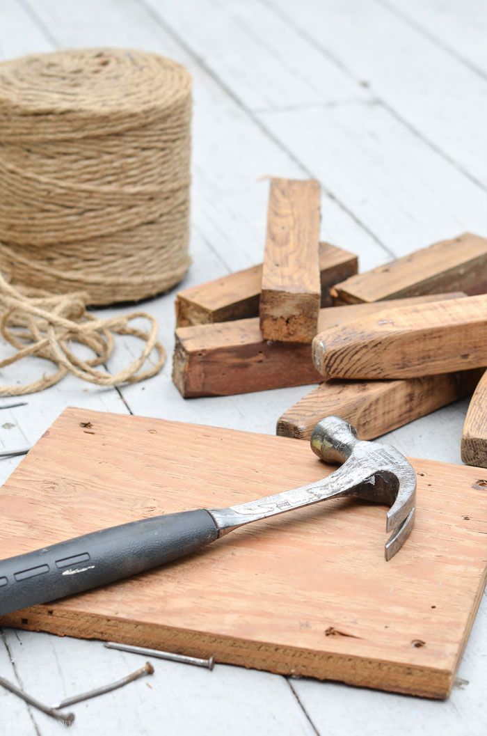 This post teaches you how to make a rustic farmhouse footstool by wrapping the top with twine! Hammer lying on board
