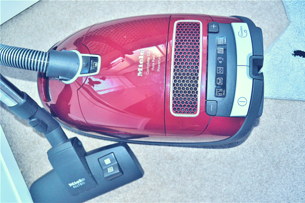 Miele Complete C3 Pure Red Bagged Cylinder Vacuum Cleaner lying down on the floor photographed from above showing the digital display