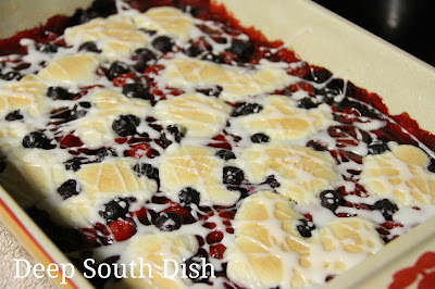 A cookie bar made with cherry pie filling and blueberries and drizzled with a powdered sugar glaze.