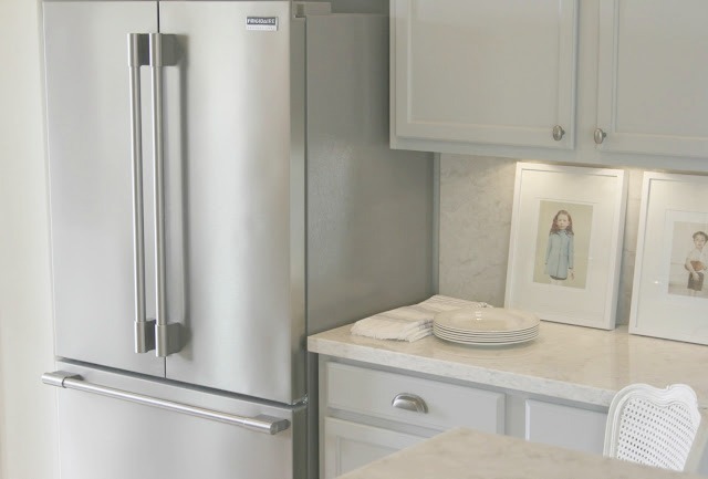 Serene simple chic Nordic French kitchen with stainless refrigerator and Soprano quartz countertop