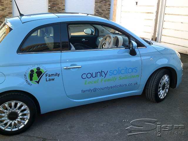 County Solicitors vehicle livery 'county solicitors' logo is on the side of the door in two different colour blues. Underneath the logo, in green is text 'Local Family Solicitors' under that is the email address family@countysolicitors.co.uk. To the left the Family Law logo from the law society accredit.