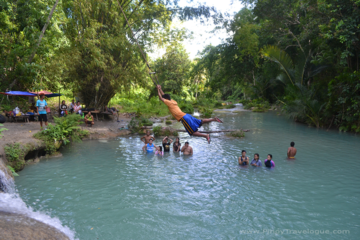 A local swinging like Tarzan at Cambugahay Falls