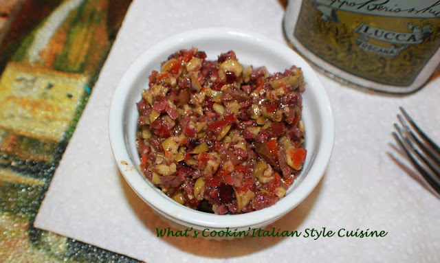 Best Two Olive Tapenade Appetizer this is a delicious olive medley chopped fine called olive tapenade. It's in a white filled ramekin filling with kalamata, green and black olives