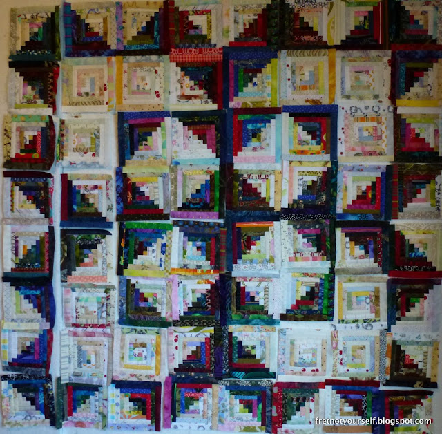Log cabin quilt, medallion variation Half-inch logs in dark and light form a medallion layout.
