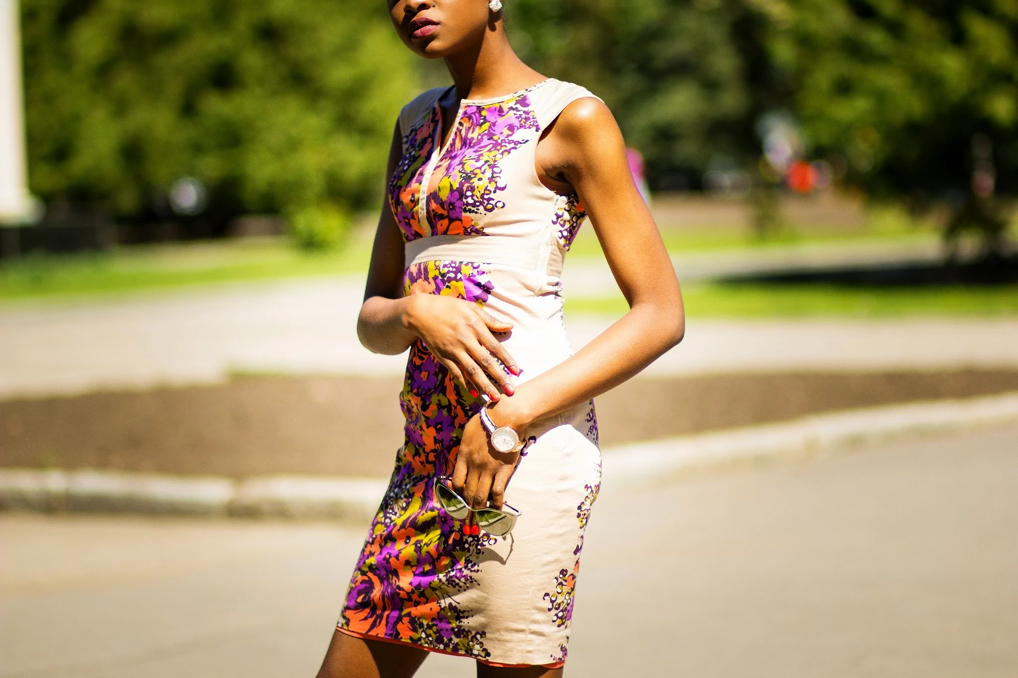 A stunning floral midi dress with orange and yellow flower designs, paired with bold purple and black gladiator heels.