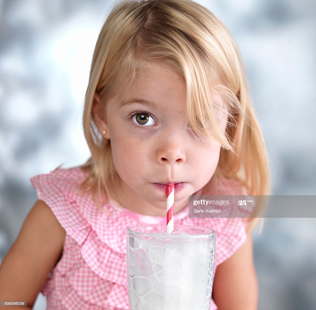 toddler blowing bubbles in milk