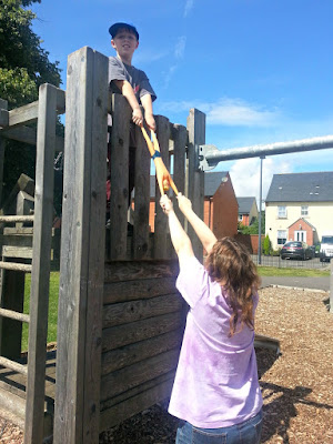 Two children at a playground stretching Stretch Armstrong