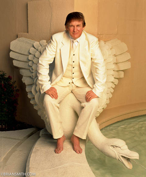 image of Donald Trump in a white suit and bare feet, sitting on the back of a white swan fountain beside a pool
