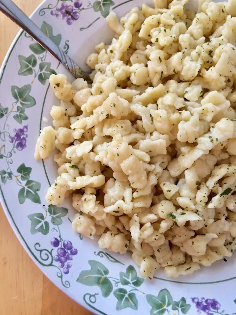 Bowl of Spatzle topped with parsley.