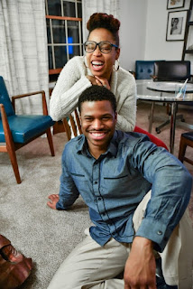Man and women spending time together Husband sitting on floor below wife in chair.