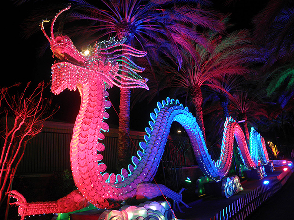 Porcelain Dragon Sculpture under Palm trees with Colorful Illumination