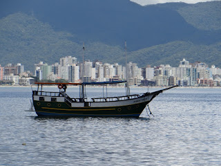 Barco de excursiones sobre el mar con la ciudad de fondo