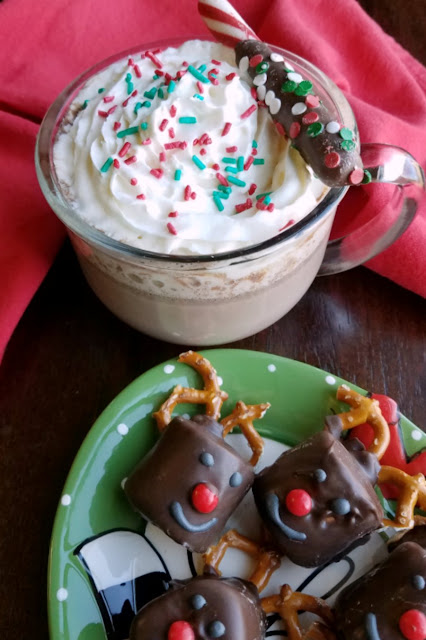 Come in from playing in the snow to a hot mug of rich, creamy and delicious hot chocolate. Making it in the slow cooker means it's super simple and hot and ready when you are. plate of chocolate dipped marshmallows next to mug of hot chocolate