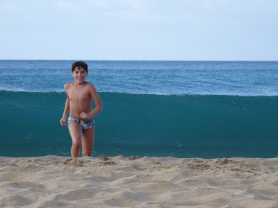 Crianças se divertem com as ondas imensas na praia da Conceição