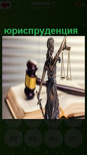молоток, книга и статуэтка относящиеся к юриспруденции