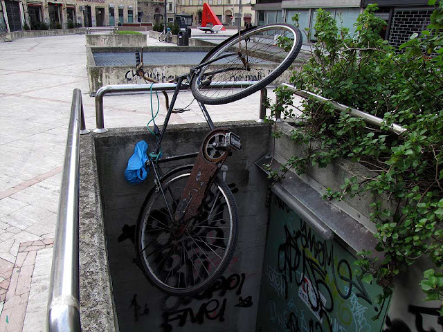 Bicycle hanging from a railing, piazza Attias, Livorno