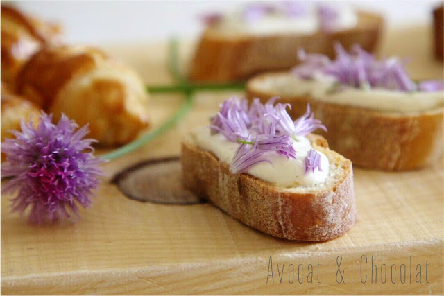 alt="petite tranche de pain tartinée de serré et décorée de fleurs de ciboulette"