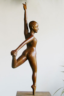 Femme gracieuse, vue de profil, en chaussons et collant de danse classique exécute une figure