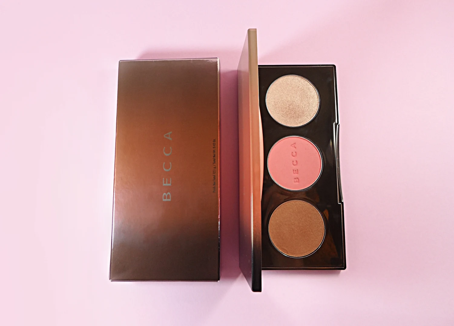 close-up of makeup contouring palette by Becca Cosmetics on a studio's rosy background