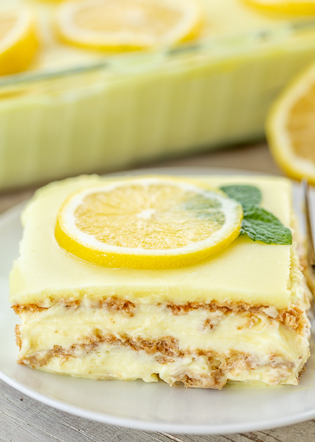 No-Bake Lemon Eclair Cake Recipe - lemon pudding, cool whip and graham crackers layered and topped with lemon frosting. It gets better the longer it sits in the fridge - it is just SO hard to wait to eat it. SOOO good. People go nuts over this easy dessert recipe! Great for parties and potlucks. There are NEVER any leftovers! #nobakedessert #dessert #lemon #nobake No-Bake Lemon Eclair Cake Recipe - lemon pudding, cool whip and graham crackers layered and topped with lemon frosting. It gets better the longer it sits in the fridge - it is just SO hard to wait to eat it. SOOO good. People go nuts over this easy dessert recipe! Great for parties and potlucks. There are NEVER any leftovers! #nobakedessert #dessert #lemon #nobake