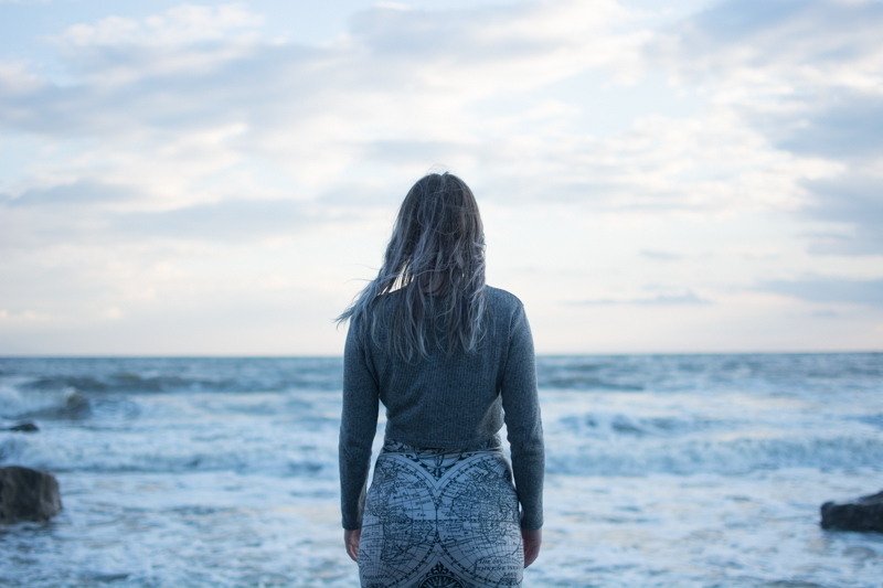 portrait of a girl on the beach long sleeve crop top black milk ancient maps bodycon dress big hipster glasses crystal necklace