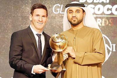 Barcelona striker Lionel Messi receiving the trophy for best player of the year during the Dubai Globe Soccer award in Dubai. (AFP Photo)
