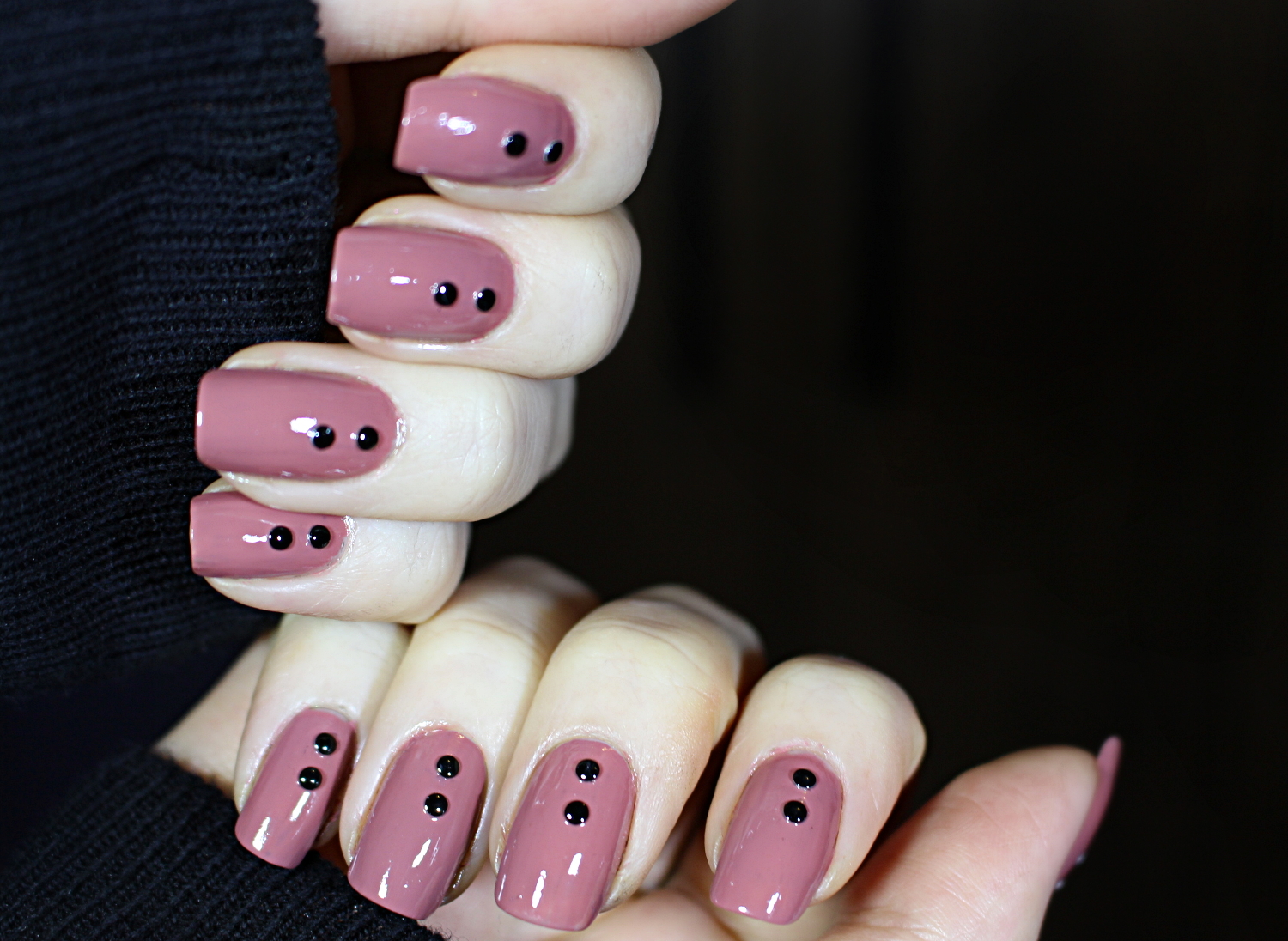 close-up of a simple, punk style nail look on short nails decorated with studs