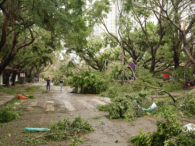 people making their way through debris from Typhoon Hato at the Bay Bar Street in Zhuhai