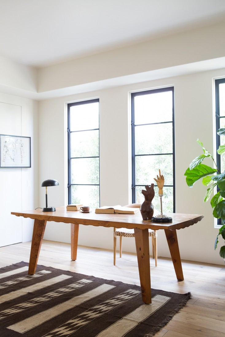 The downstairs office has an en suite bathroom (and shower), and can also be used as a bedroom. The desk is by LA designer Andrew Riiska. When Herzig went looking for wood flooring, she was surprised to discover affordable canewood, engineered flooring made locally using European white oak: “It’s about $6 to $8 a square foot. You can’t find long boards, but otherwise it looks identical to stuff that’s double the price.” Come see more Rustic Spanish Villa Interior Design Inspiration!