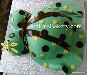Unique green, yellow, and brown polka dot baby bump shower cake with edible dragonfly and bow