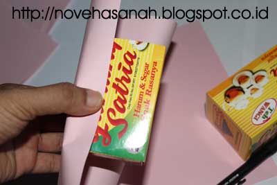 langkah-langkah membuat kerajinan tangan dari kotak kemasan teh celup dan stik es krim yang gampang berikutnya, bungkus kedua kota yang telah dipotong. Ingat kita menggunakan potongan kotak yang panjangnya 9 cm. Sisa potongan kotak kemasan teh celup dapat disimpan untuk bahan prakarya lainnya nanti.