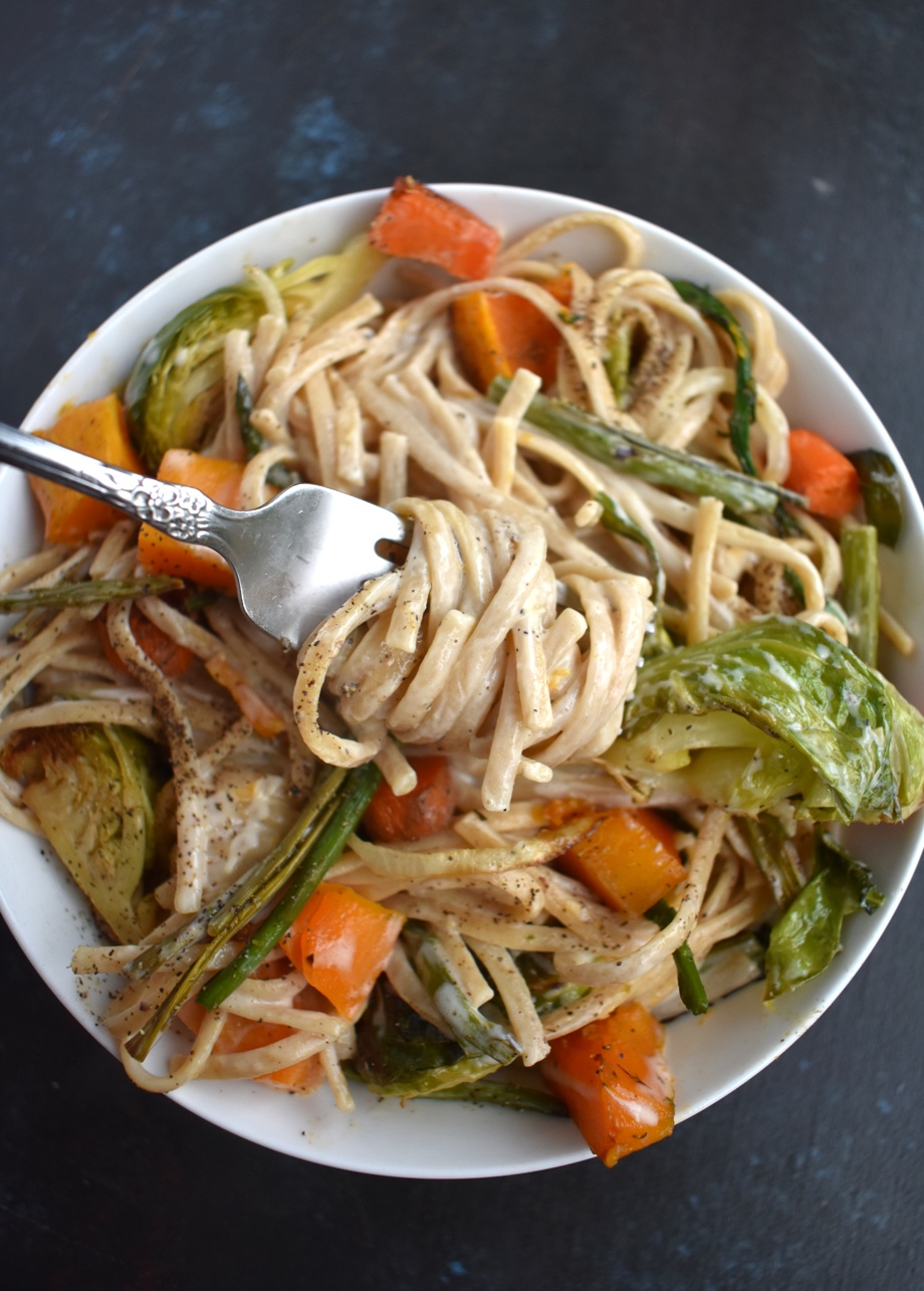Roasted Vegetable Fettuccine Alfredo is loaded with a garlicky, cheesy creamy sauce with whole-wheat noodles, roasted butternut squash, Brussels sprouts, carrots, onions and asparagus! www.nutritionistreviews.com
