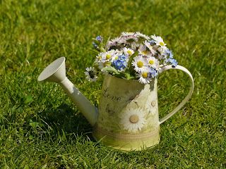 watering cans with flowers painted on the sides