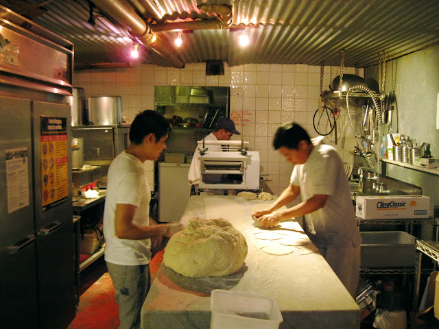 Cooks in the back stretch dough for meat pies at Tuck Shop in New York City